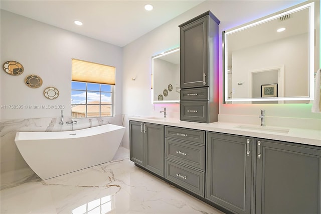 full bath featuring a soaking tub, marble finish floor, a sink, and double vanity