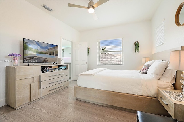 bedroom featuring light wood finished floors, visible vents, and a ceiling fan