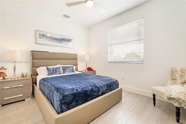 bedroom featuring a ceiling fan, light wood-type flooring, visible vents, and baseboards