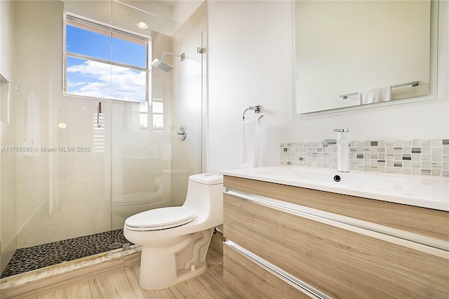 full bathroom with vanity, backsplash, a shower stall, and toilet