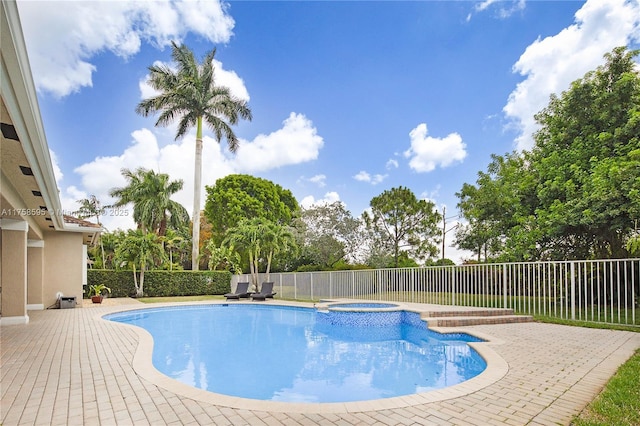 view of pool featuring a patio, a fenced backyard, and a pool with connected hot tub