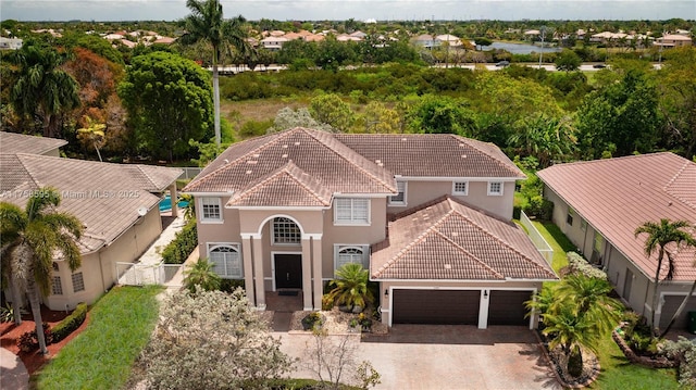 view of front facade with an attached garage, fence, a tiled roof, driveway, and stucco siding