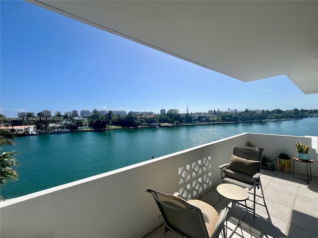 balcony featuring a water view and a city view