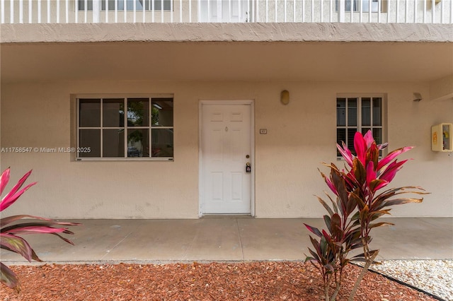 entrance to property featuring stucco siding