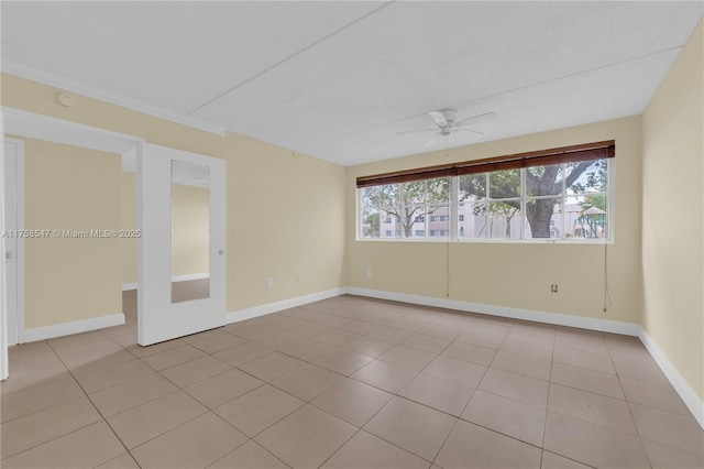 empty room featuring ceiling fan, baseboards, a wealth of natural light, and light tile patterned flooring