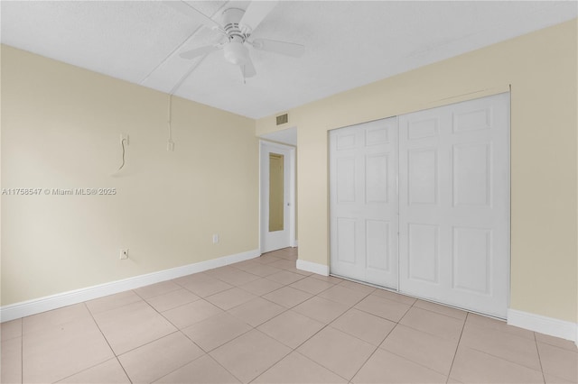 unfurnished bedroom featuring a closet, light tile patterned flooring, visible vents, and baseboards