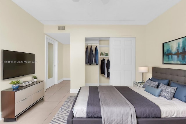 bedroom with light tile patterned floors, baseboards, visible vents, and a closet