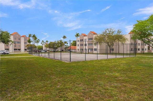 view of sport court featuring a residential view, fence, and a yard