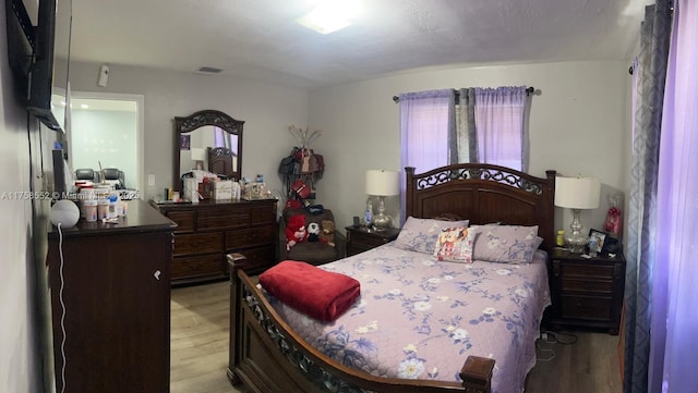 bedroom with light wood-type flooring and visible vents