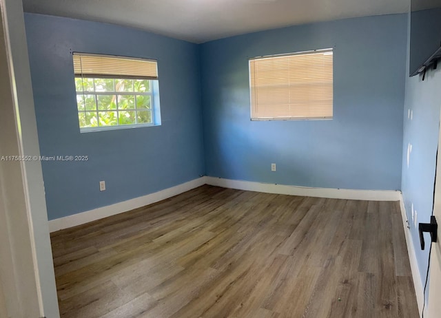 empty room featuring baseboards and wood finished floors