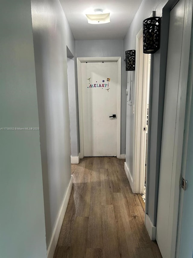 corridor featuring wood finished floors and baseboards