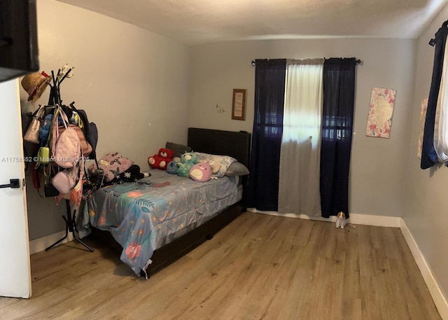 bedroom with wood finished floors and baseboards