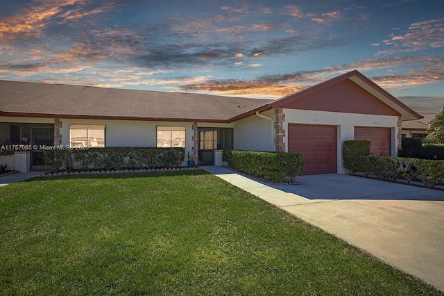 single story home with a garage, driveway, stone siding, stucco siding, and a front yard