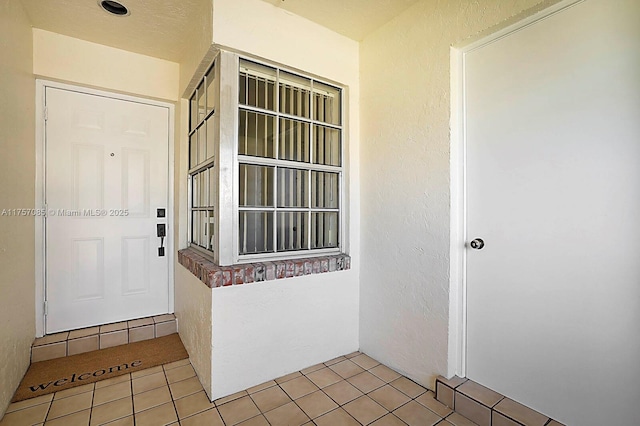 doorway to property featuring stucco siding