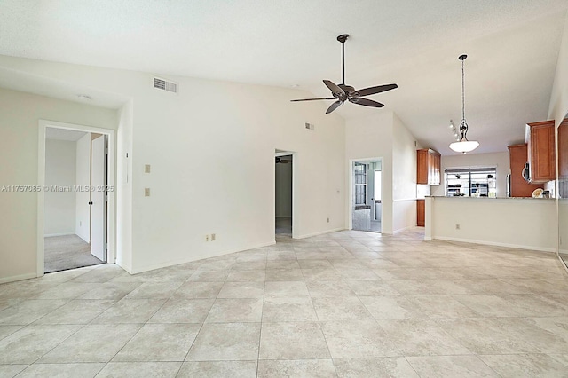 unfurnished living room with ceiling fan, lofted ceiling, visible vents, and baseboards