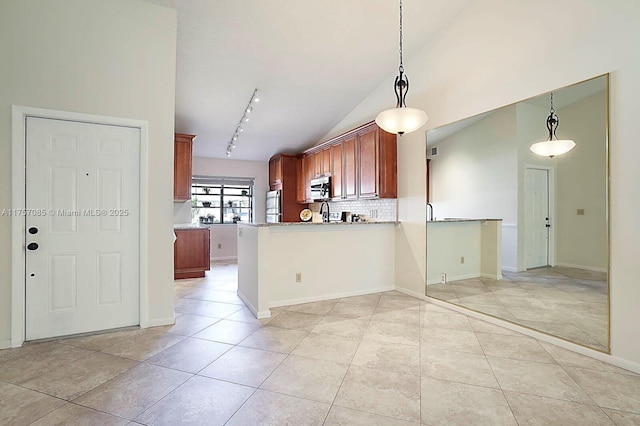 kitchen with light tile patterned floors, a peninsula, hanging light fixtures, appliances with stainless steel finishes, and decorative backsplash