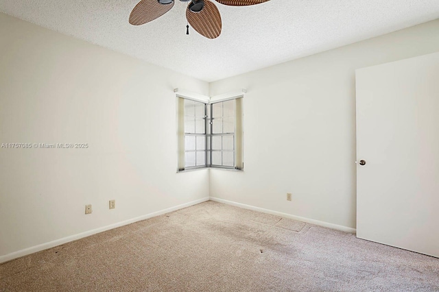 carpeted empty room featuring ceiling fan, a textured ceiling, and baseboards