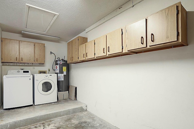 laundry room featuring a textured ceiling, washing machine and dryer, electric water heater, cabinet space, and attic access