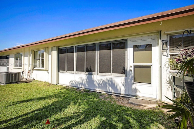 view of home's exterior with a lawn and central AC