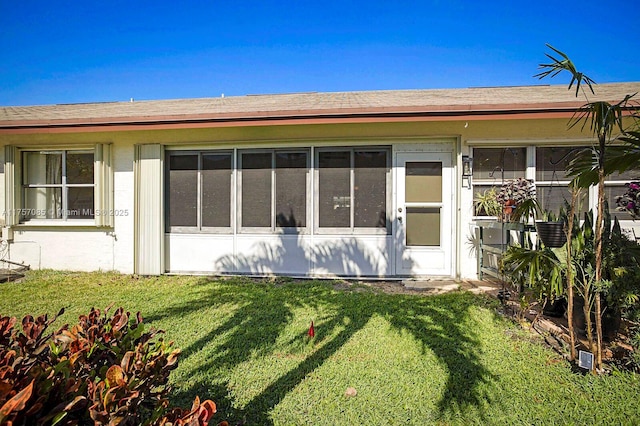 rear view of property featuring a lawn