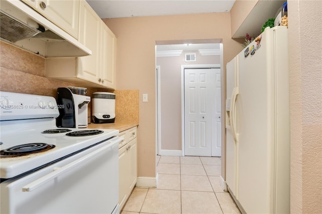 kitchen with light tile patterned floors, under cabinet range hood, white appliances, visible vents, and light countertops