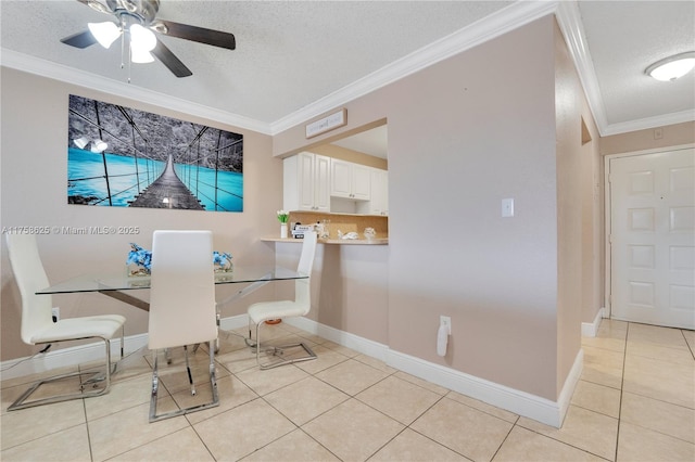 dining space with light tile patterned floors, a textured ceiling, baseboards, and crown molding