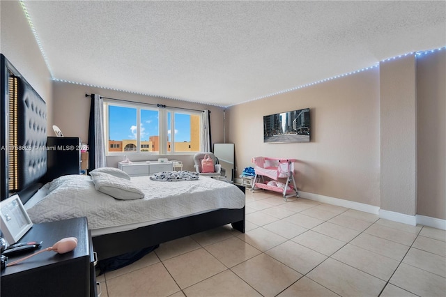 bedroom featuring a textured ceiling, baseboards, and light tile patterned floors