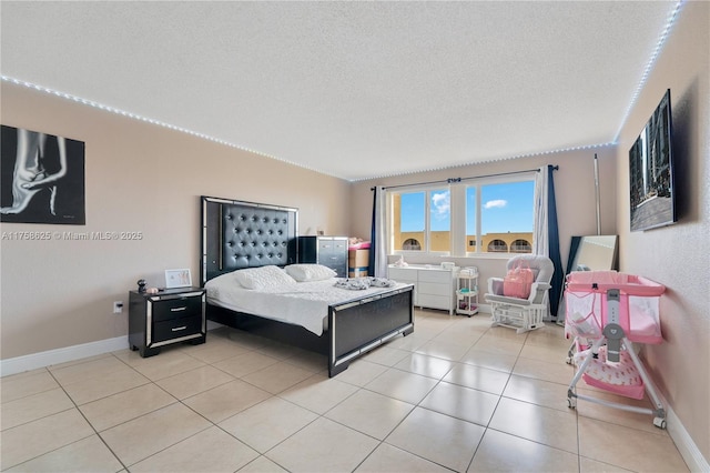 bedroom with a textured ceiling, light tile patterned flooring, and baseboards