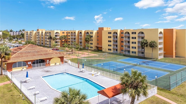 community pool with a patio area and fence