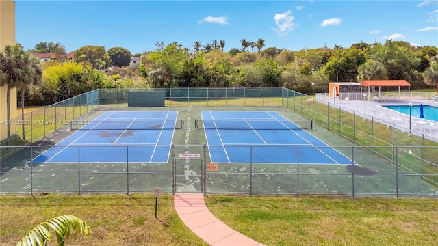 view of sport court featuring a yard and fence