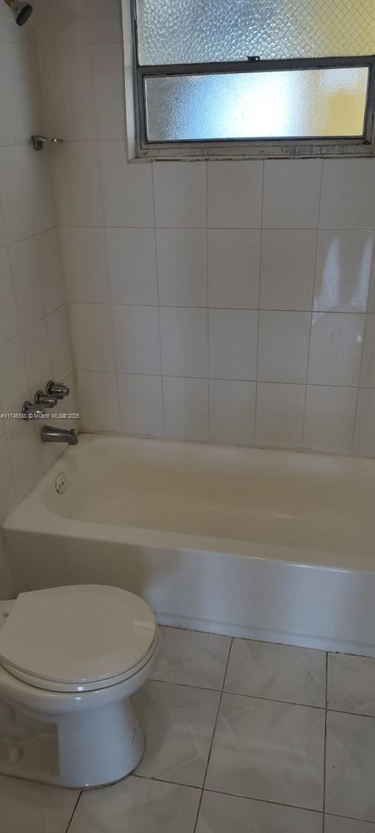 bathroom with tub / shower combination and toilet