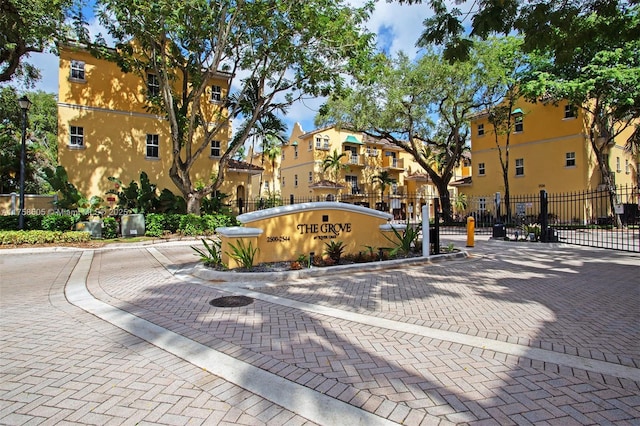 view of street featuring curbs, a gated entry, and a residential view