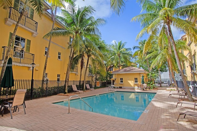 community pool featuring fence and a patio