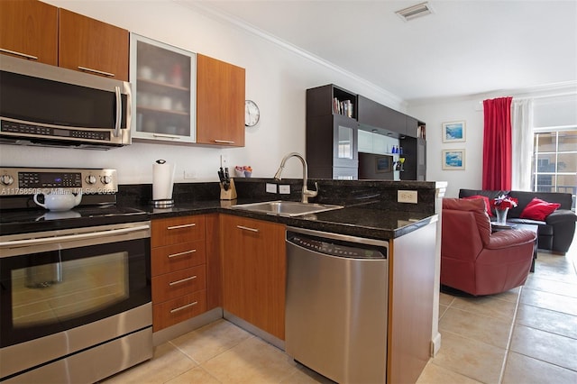 kitchen with stainless steel appliances, a peninsula, a sink, visible vents, and brown cabinets