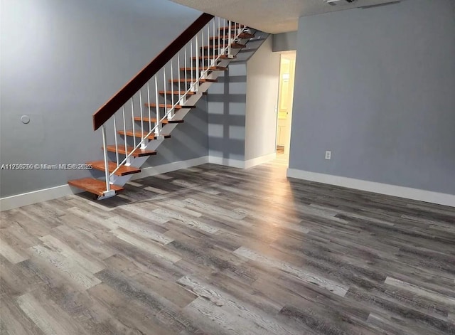 interior space featuring stairway, wood finished floors, visible vents, and baseboards