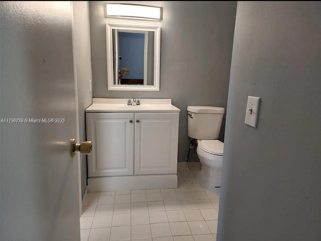 bathroom with tile patterned flooring, vanity, and toilet