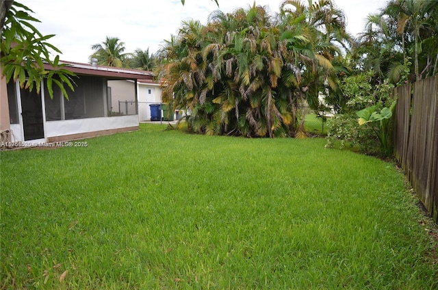 view of yard with a fenced backyard and a sunroom