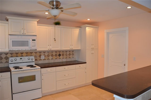 kitchen featuring white appliances, dark countertops, and white cabinets