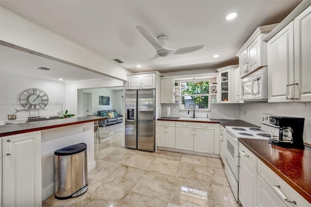 814 NE 4th St, Hallandale Beach, FL 33009 - kitchen with visible vents, a sink, dark countertops, white appliances, and a ceiling fan