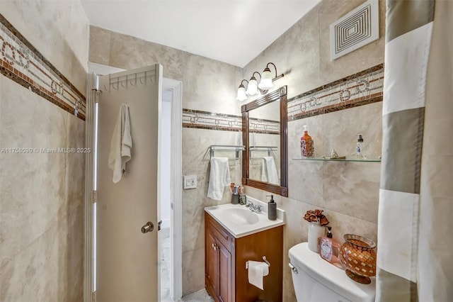 814 NE 4th St, Hallandale Beach, FL 33009 - bathroom with toilet, vanity, visible vents, and tile walls