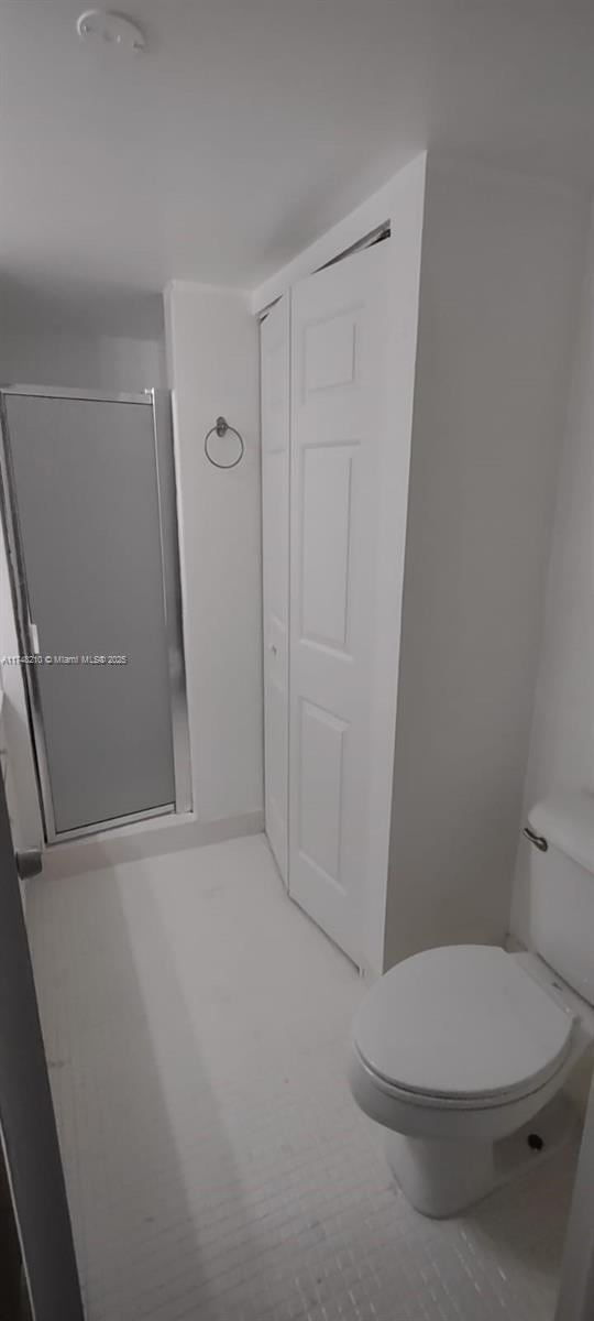 full bathroom featuring toilet and a stall shower