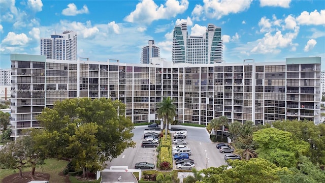 view of property featuring uncovered parking and a view of city