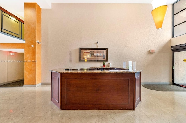 office area featuring a textured wall and baseboards