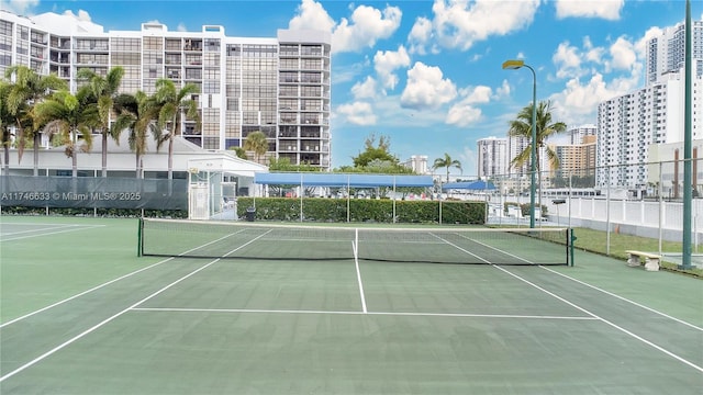 view of sport court with community basketball court, fence, and a city view