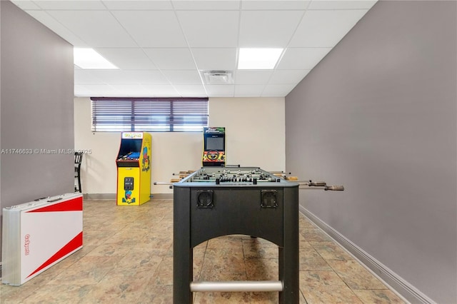 game room with a paneled ceiling, visible vents, and baseboards