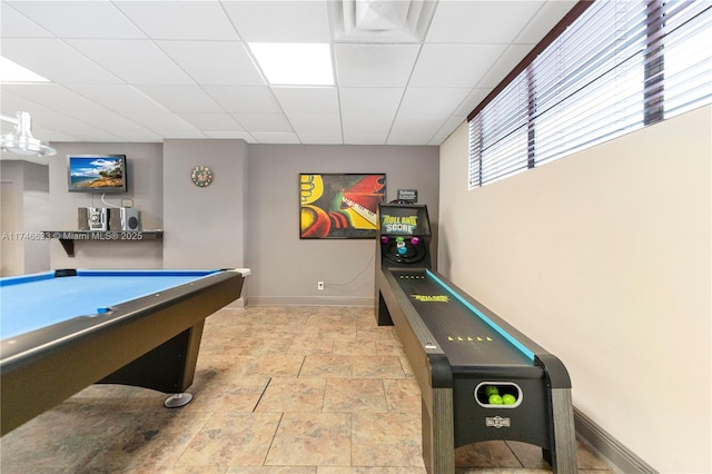 rec room with stone finish floor, a drop ceiling, billiards, and baseboards