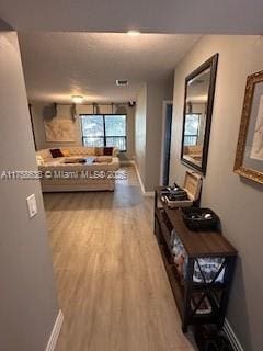 hallway featuring baseboards and wood finished floors