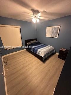 bedroom with ceiling fan and wood finished floors