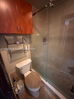 full bathroom with a shower stall and toilet