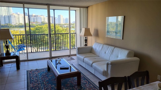 tiled living room featuring a view of city, a wall of windows, and a textured ceiling